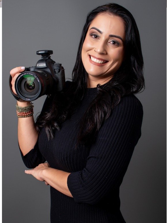 Vanessa Serrano, fotógrafa especialista em newborn, segurando câmera profissional